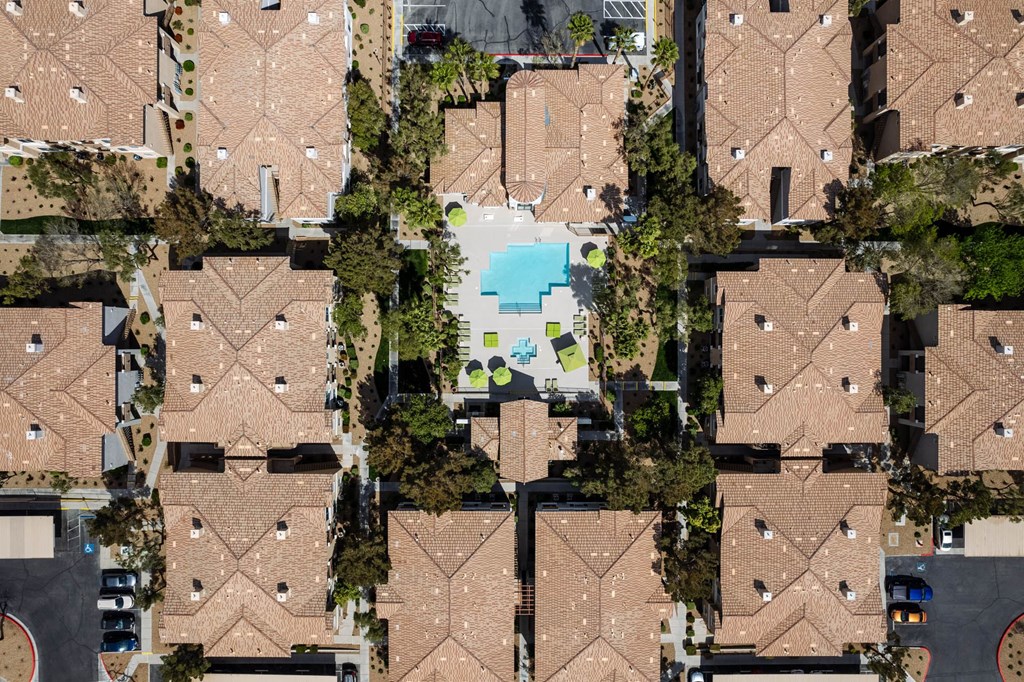 a birdseye view of a group of houses with a pool in the middle