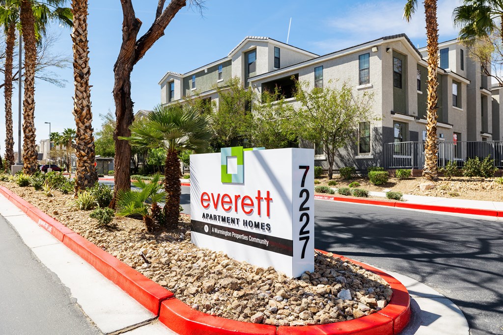 A sign for Everett Apartment Homes is in front of a building.