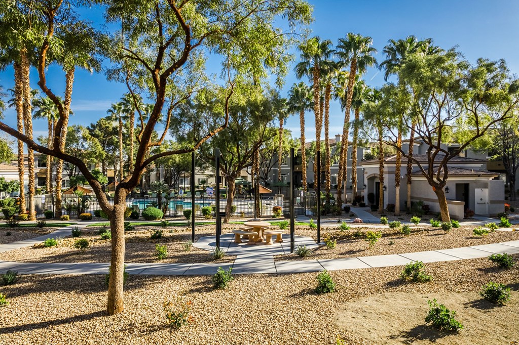 A park with trees and benches in the foreground.