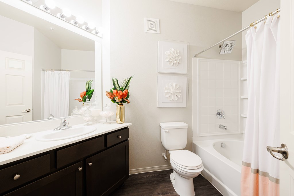 A white bathroom with a toilet, sink, and shower.