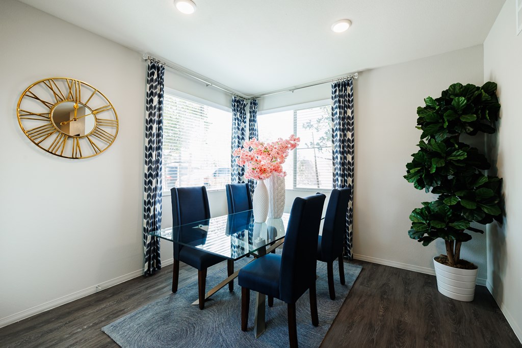 A living room with a glass table and blue chairs.