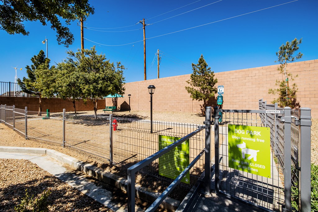 A dog park sign is displayed on a fence.