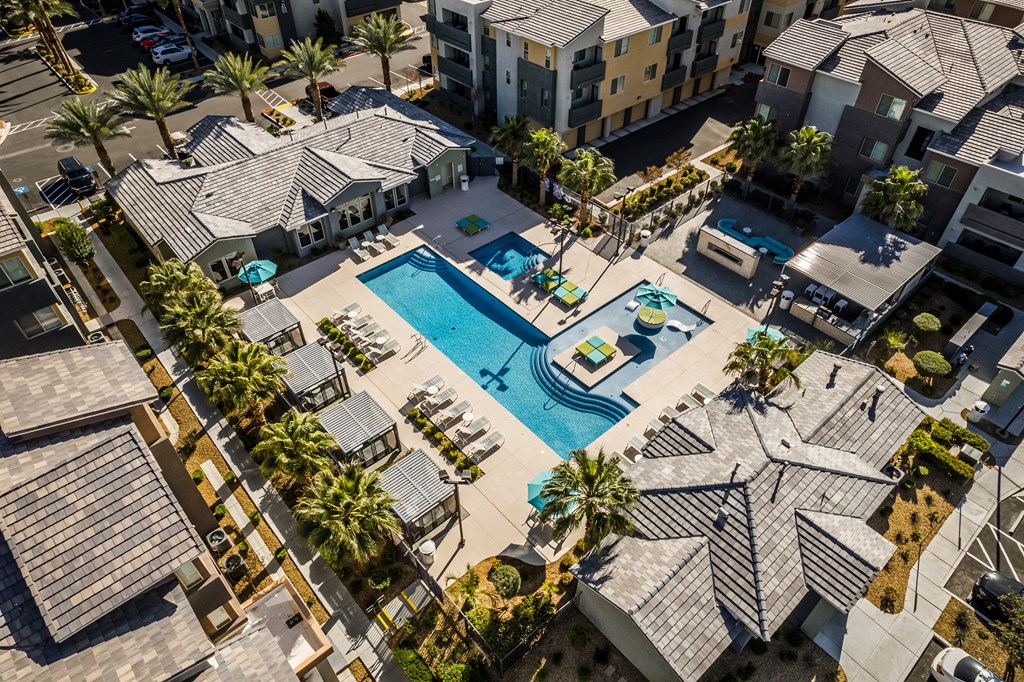 A bird's eye view of a residential area with a swimming pool.