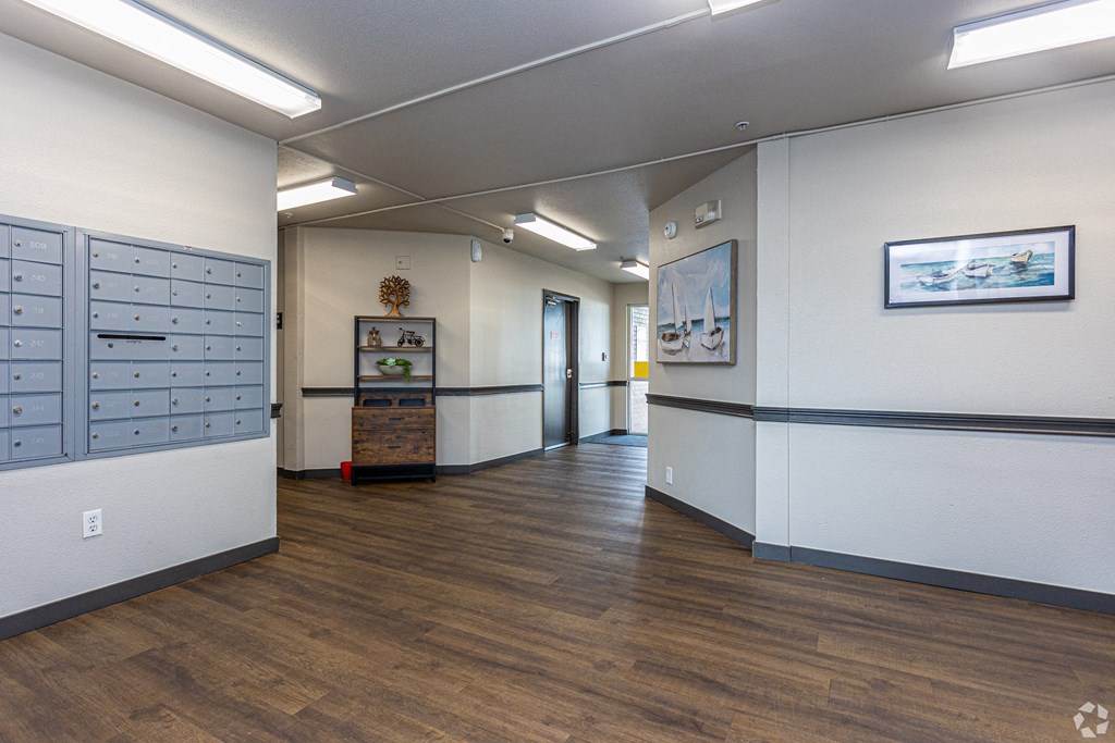 a hallway with white walls and wood floors and lockers