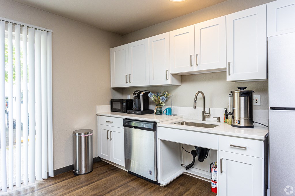 a kitchen with white cabinets and stainless steel appliances and a window