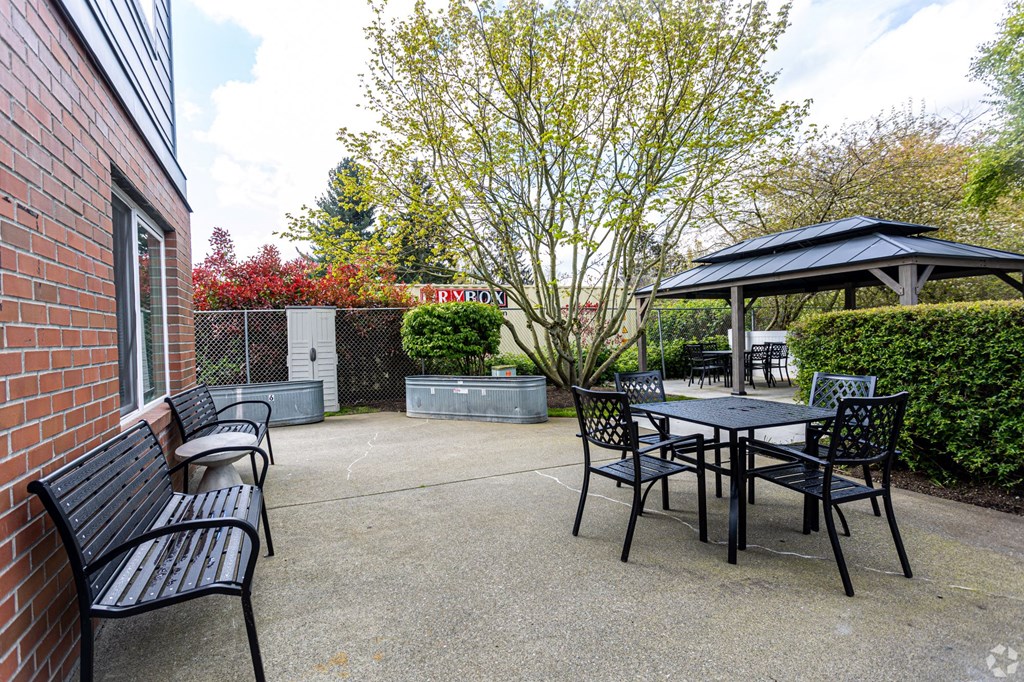 a patio with a table and chairs and a gazebo