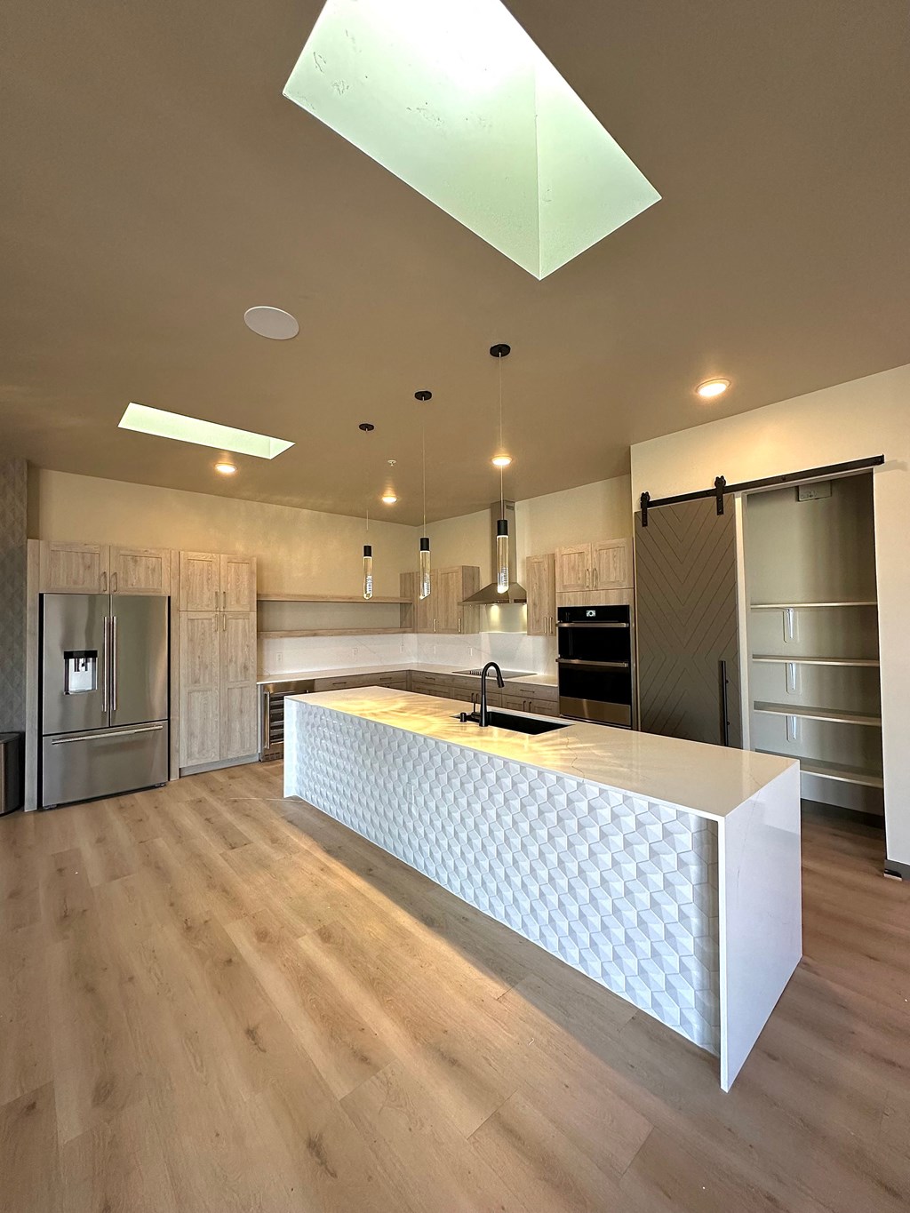 a kitchen with a large white island with a yellow countertop