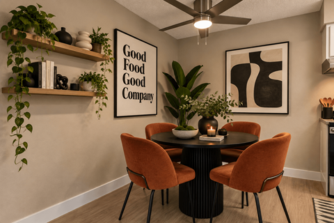 Dining area with round table and orange upholstered chairs at Zoom Apartments, Las Vegas