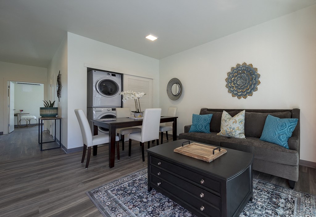 a living room with a couch and a table with a washer and dryer at ROCKY HILL VETERANS HOUSING, VACAVILLE