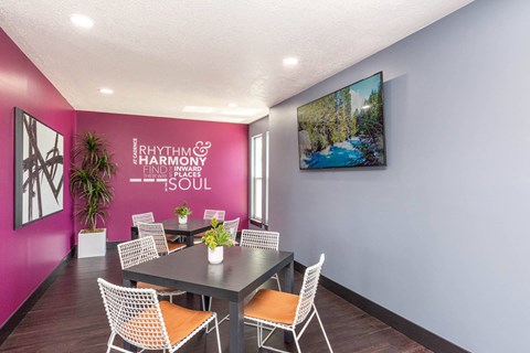 a dining room with a table and chairs and a pink wall at Cadence Apartments, Roy Utah