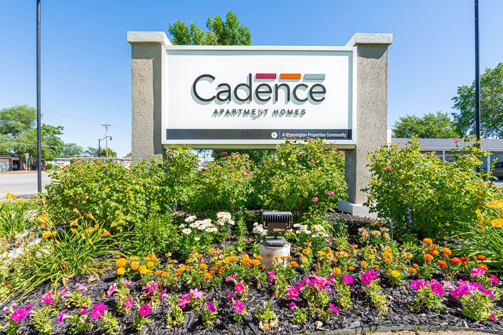 the sign for cadence parkway homes in front of a flower garden at Cadence Apartments, Roy, UT