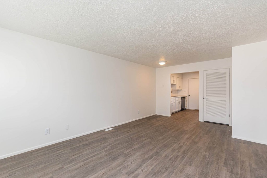a living room and kitchen with wood flooring and white walls at Cadence Apartments, Utah