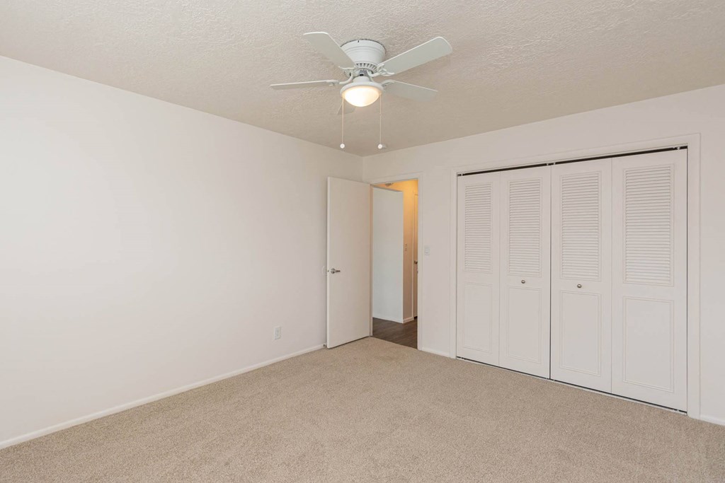 a bedroom with a ceiling fan and a closet at Cadence Apartments, Roy, UT 84067