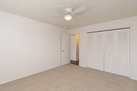 a bedroom with a ceiling fan and a closet at Cadence Apartments, Roy, UT 84067