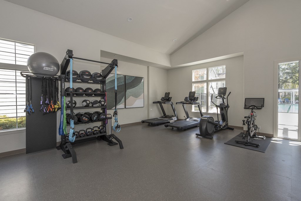 a spacious fitness room with treadmills and other exercise equipment