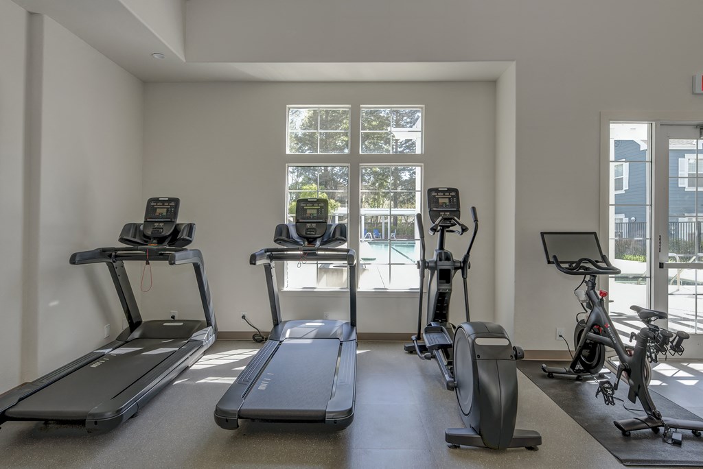 a gym with treadmills and exercise bikes