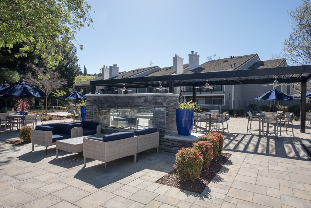 A patio with a fireplace and seating area at Kirker Creek Apartments, Pittsburg, California