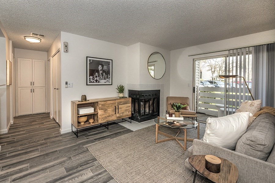 Apartments for Rent Citrus Heights - The Arlo - Living Room with a Fireplace, Wood-Style Flooring, a Sliding Glassdoor to a Private Balcony/Patio, and Stylish Decor