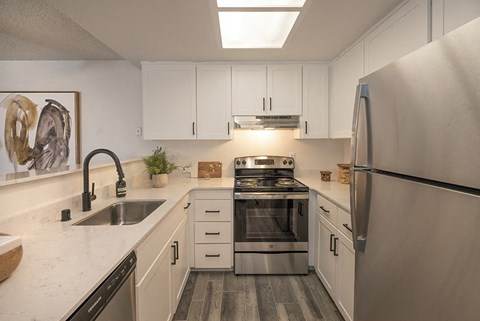 a kitchen with stainless steel appliances and white cabinets