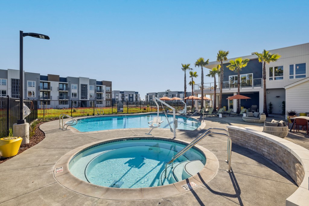 a hot tub and pool with a building in the background