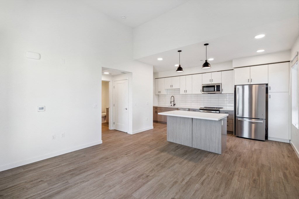 an empty living room with a kitchen with a stainless steel refrigerator at 38° NORTH, Santa Rosa, 95404