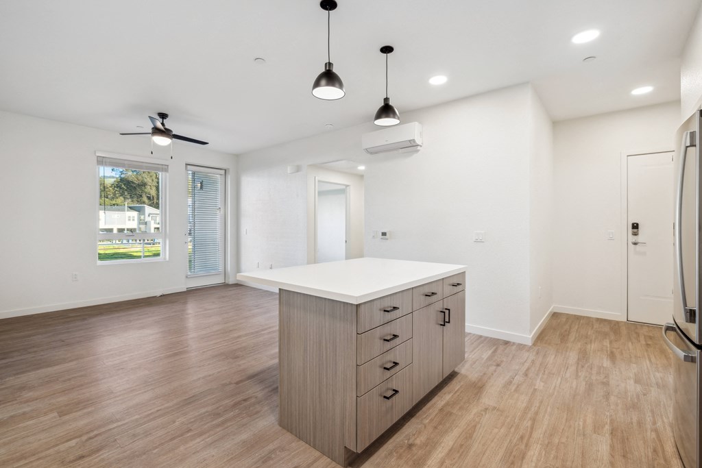 the living room and kitchen in a new home with white walls and wood flooring at 38° NORTH, Santa Rosa
