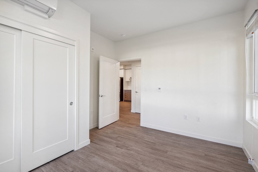 an empty bedroom with white walls and wood flooring at 38° NORTH, California