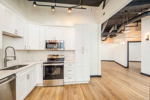 A modern kitchen with white cabinets and stainless steel appliances.