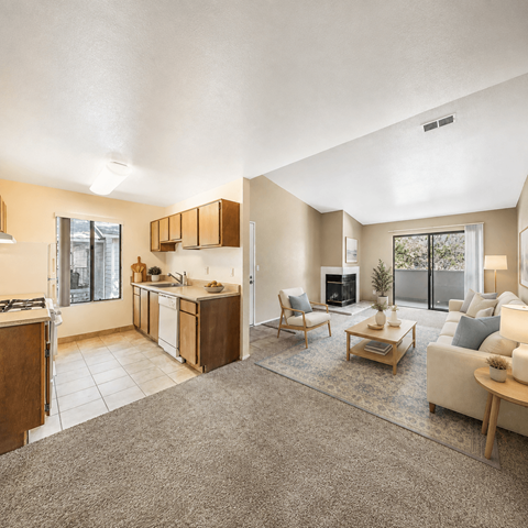 A well-lit, spacious living room with a kitchen area in the background.