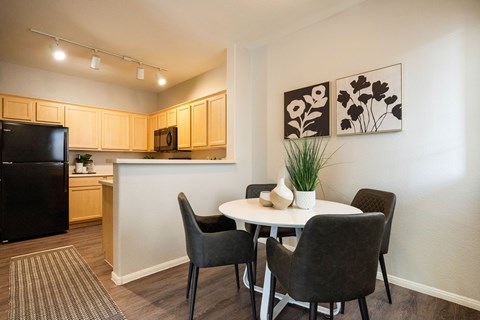 A kitchen with a table and chairs.