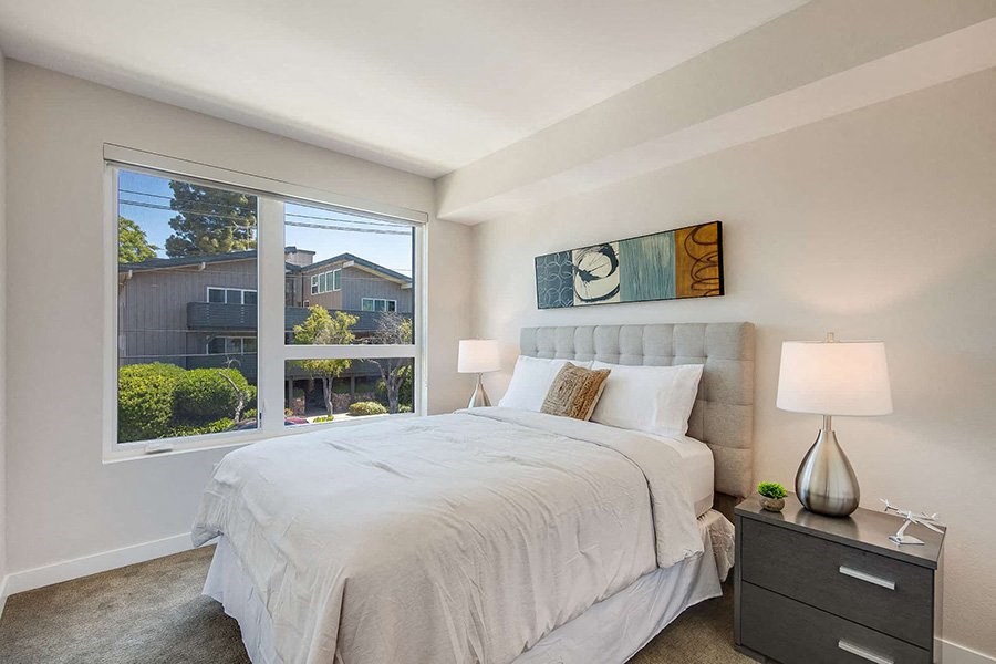 a bedroom with a large window and a large bed