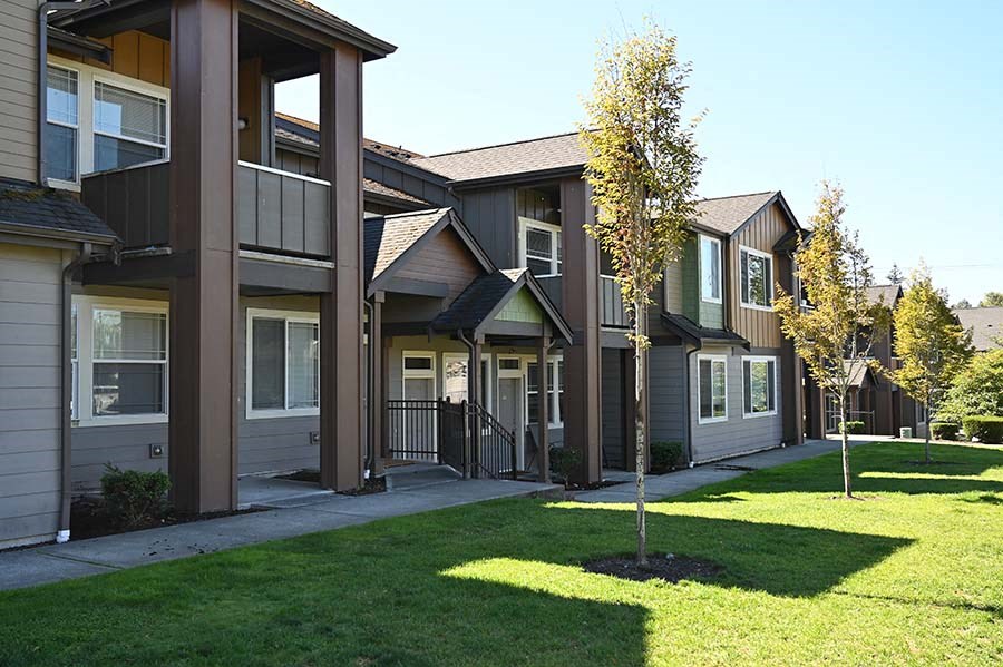 Exterior view of buildings with large grass area Bella on Canyon Apartments in Puyallup Wa