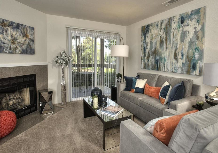 Apartments in Richmond - Bella Vista at Hilltop - Living Room with Carpet Flooring, Sliding Glass Door to Patio/Balcony, a Fireplace, and Stylish Decor
