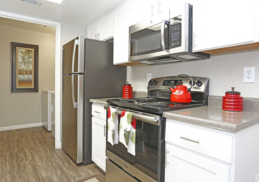 Apartments Richmond - Bella Vista at Hilltop - Kitchen with Stainless Steel Appliances, White Cabinets, and Plank Flooring