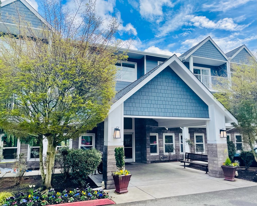 A blue building with a white roof and a tree in front  at Everett Senior Community, Everett, Washington