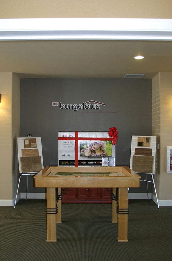 a table with four chairs in front of a wall with a sign on it
