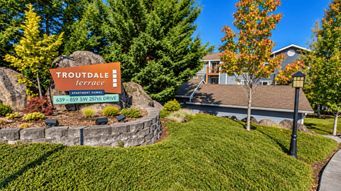 A sign for Troutdale Terrace stands in front of a house.