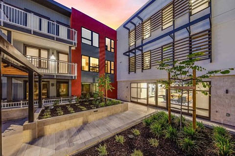 a picture of a building with a lot of windows and a courtyard in front of it