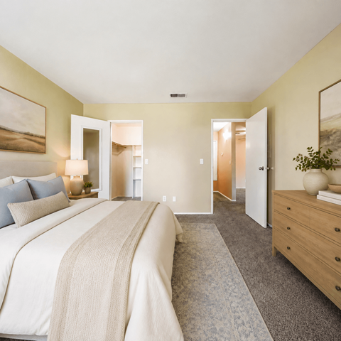 A bedroom with a large bed and a dresser.