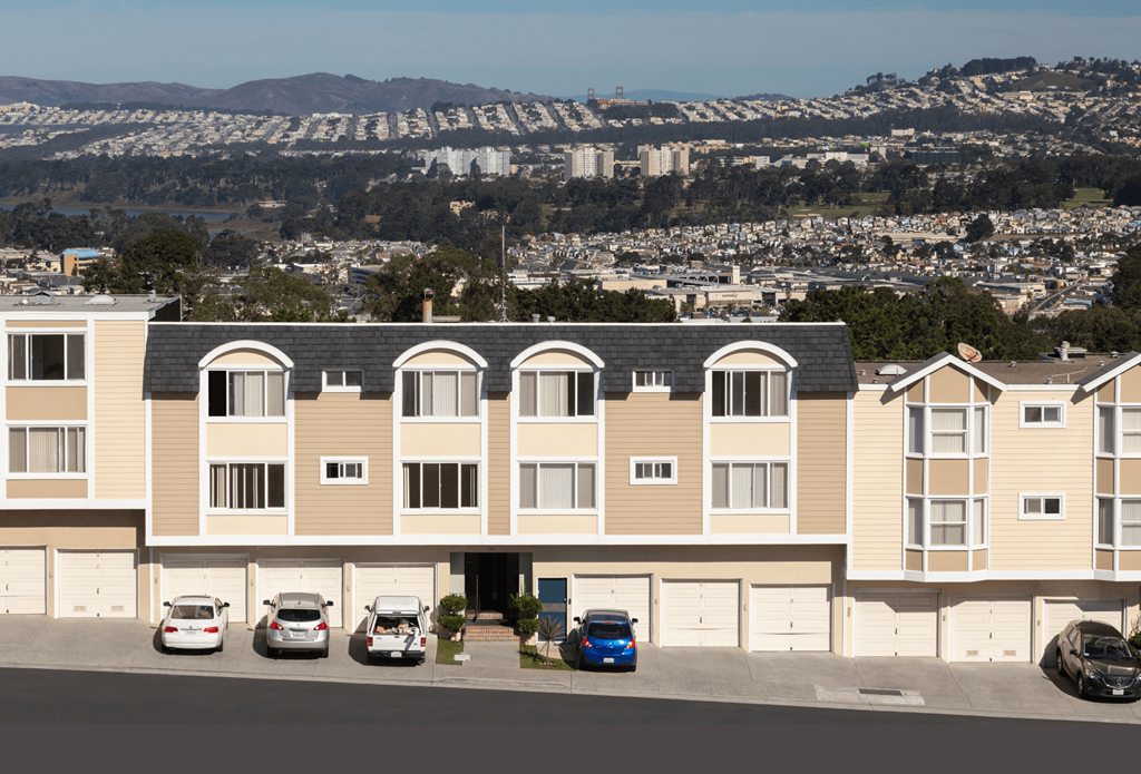 Dale City, CA Apartments-Terrace View-Buidings with garages, paved walkways, roads, and city views in the background