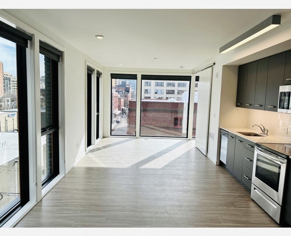 a kitchen with a large window and a door that leads to a balcony