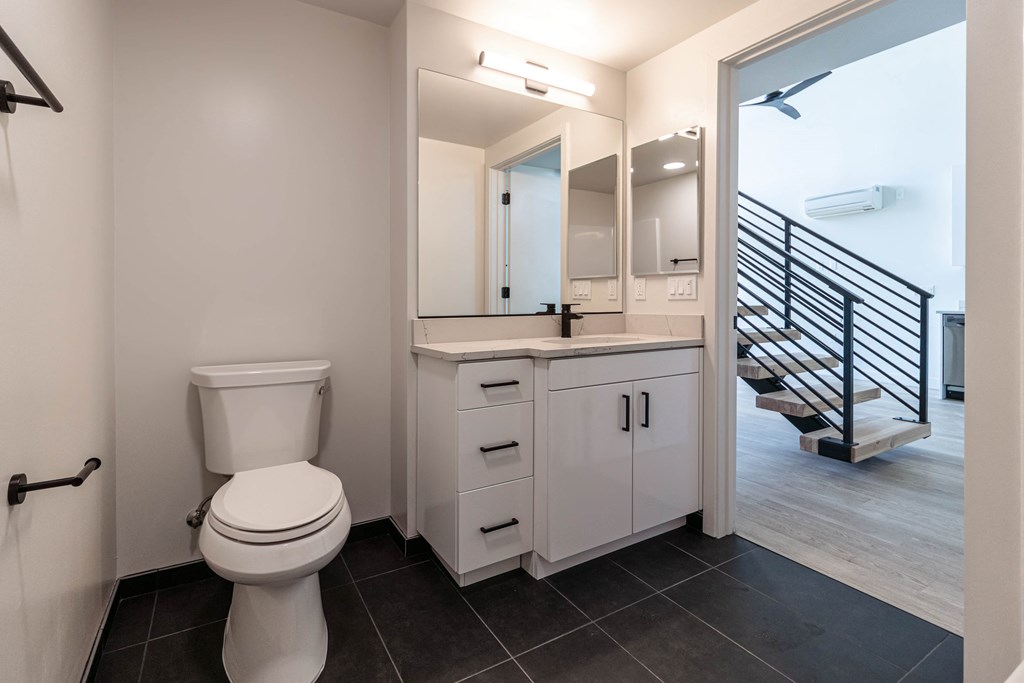 a bathroom with a toilet and a sink and a mirror