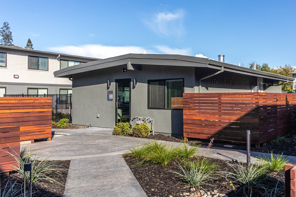 a house with a walkway and wooden fence in front of it