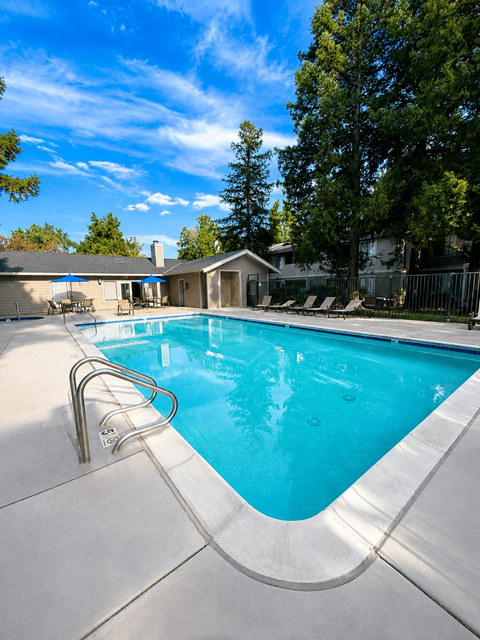 A swimming pool with a slide and a house in the background.