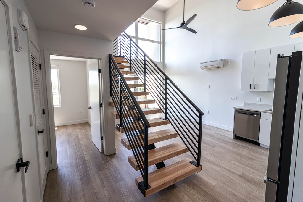 a staircase with wood treads leading up to a room with white walls and a
