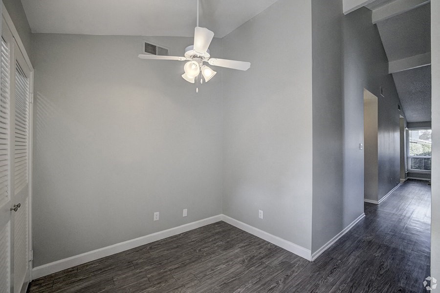 a bedroom with gray walls and a white ceiling fan