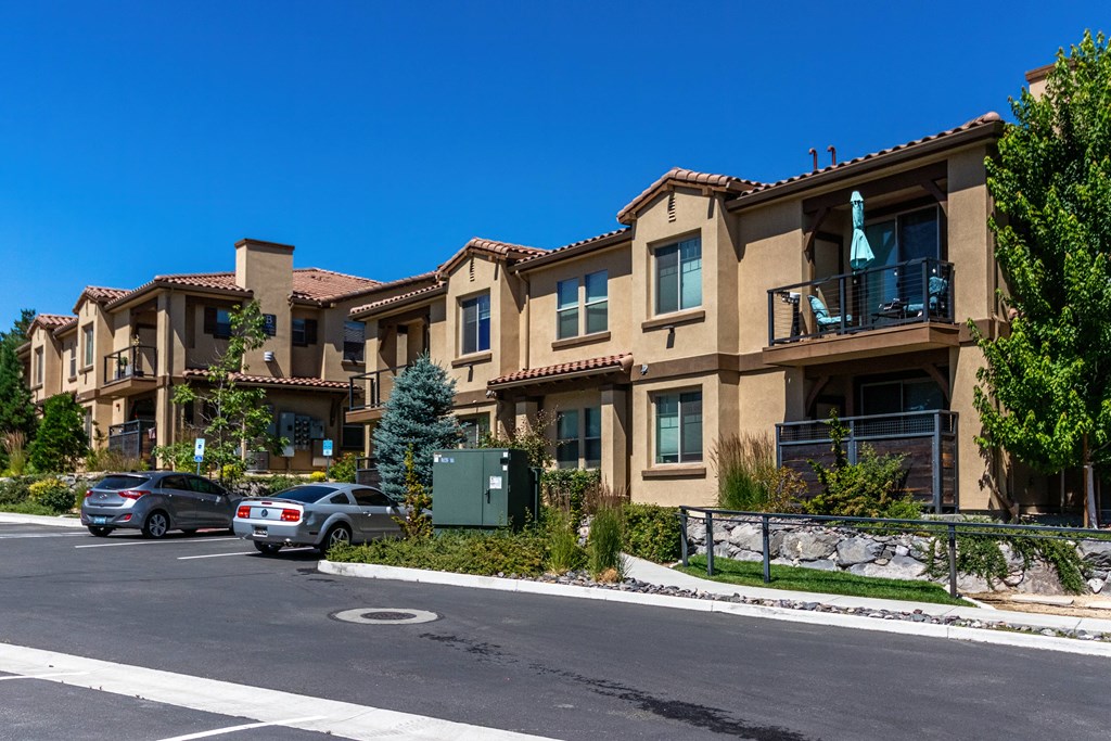 an apartment building with cars parked in front of it