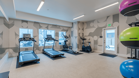 A gym with treadmills, exercise bikes, and a balloon at Falls Creek Apartments in Idaho, 83815