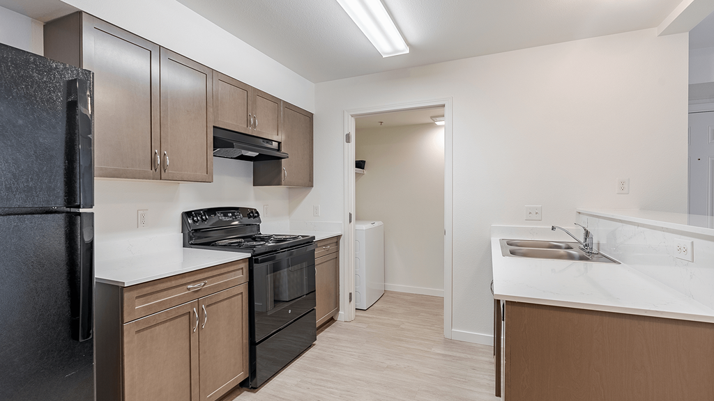 A kitchen with black appliances A kitchen with black appliances and brown cabinets at Falls Creek Apartments in Couer d'Alene, Idaho, 83815