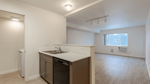 A kitchen with a white counter top and a window.